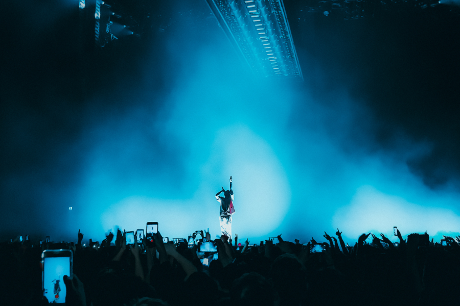 Musician on stage and concertgoers in the foreground.