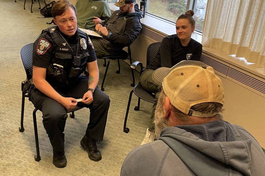 Individuals with aphasia engage in role play scenarios with law enforcement officers to raise awareness about aphasia and train communication strategies for interactions in the community.