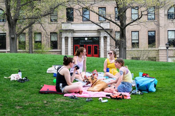 Audiology graduate students, from left to right, Vee Stanarevic, Jenny Lucke, Serena Helman, and Kelly Schneider along with Mia the dog enjoy a picnic on Bascom Hill on a hot spring day at the University of Wisconsin-Madison on May 11, 2022. Photo by Althea Dotzour / UW–Madison