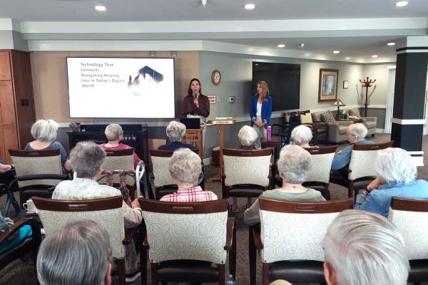 Audiology graduate student and her clinical supervisor share a presentation on hearing loss and hearing technology to a group of adults at a community senior center.