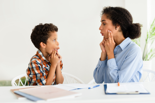 A child is working on fluency with their speech-language pathologist.