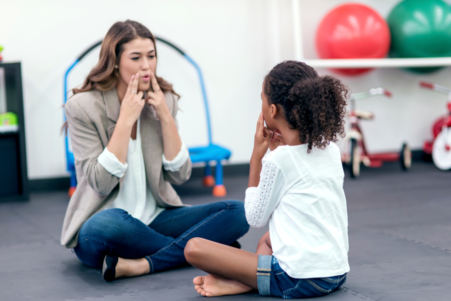 A speech pathologist works with a child on speech sound production skills.