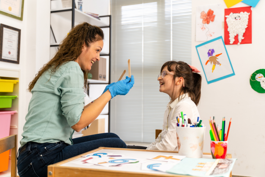 A speech pathologist works with a child on feeding therapy.